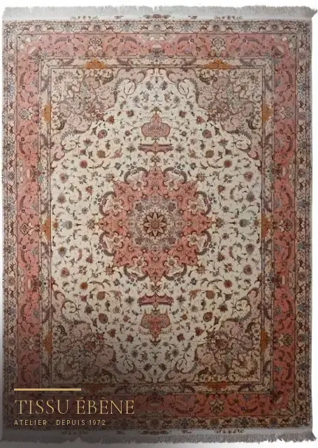Tapis persan à médaillon central, fond ivoire et bordure rose saumon, décor floral fin