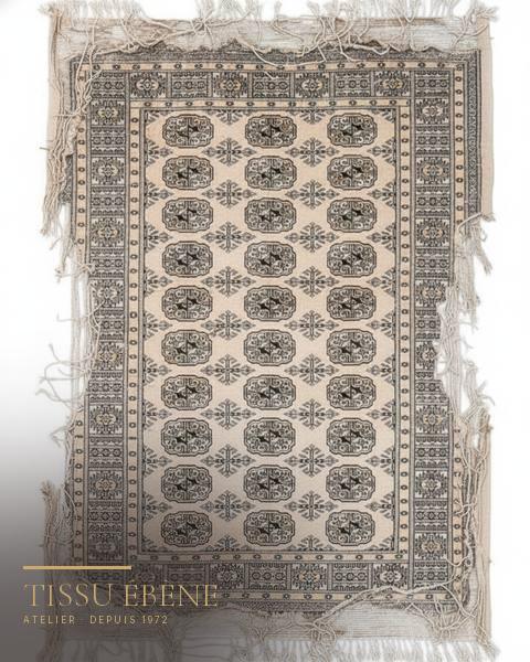 Tapis Boukhara beige à médaillons octogonaux, bordures effilochées et franges défaites, vue à plat