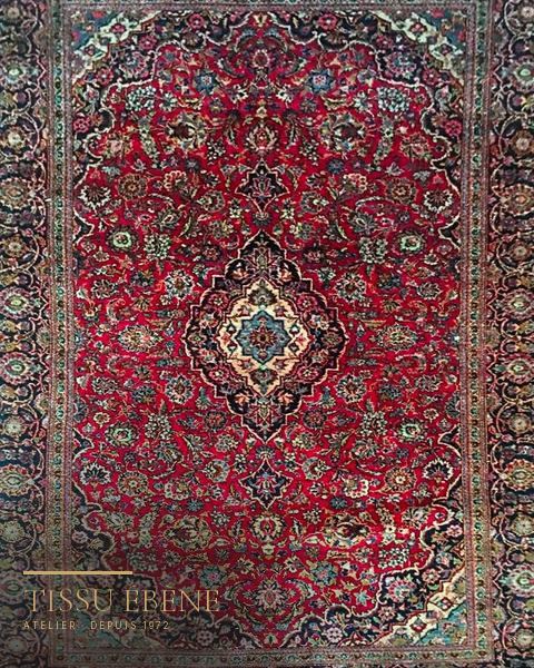 Tapis Kashan rouge à médaillon central bleu nuit et rinceaux fleuris, bordure sombre