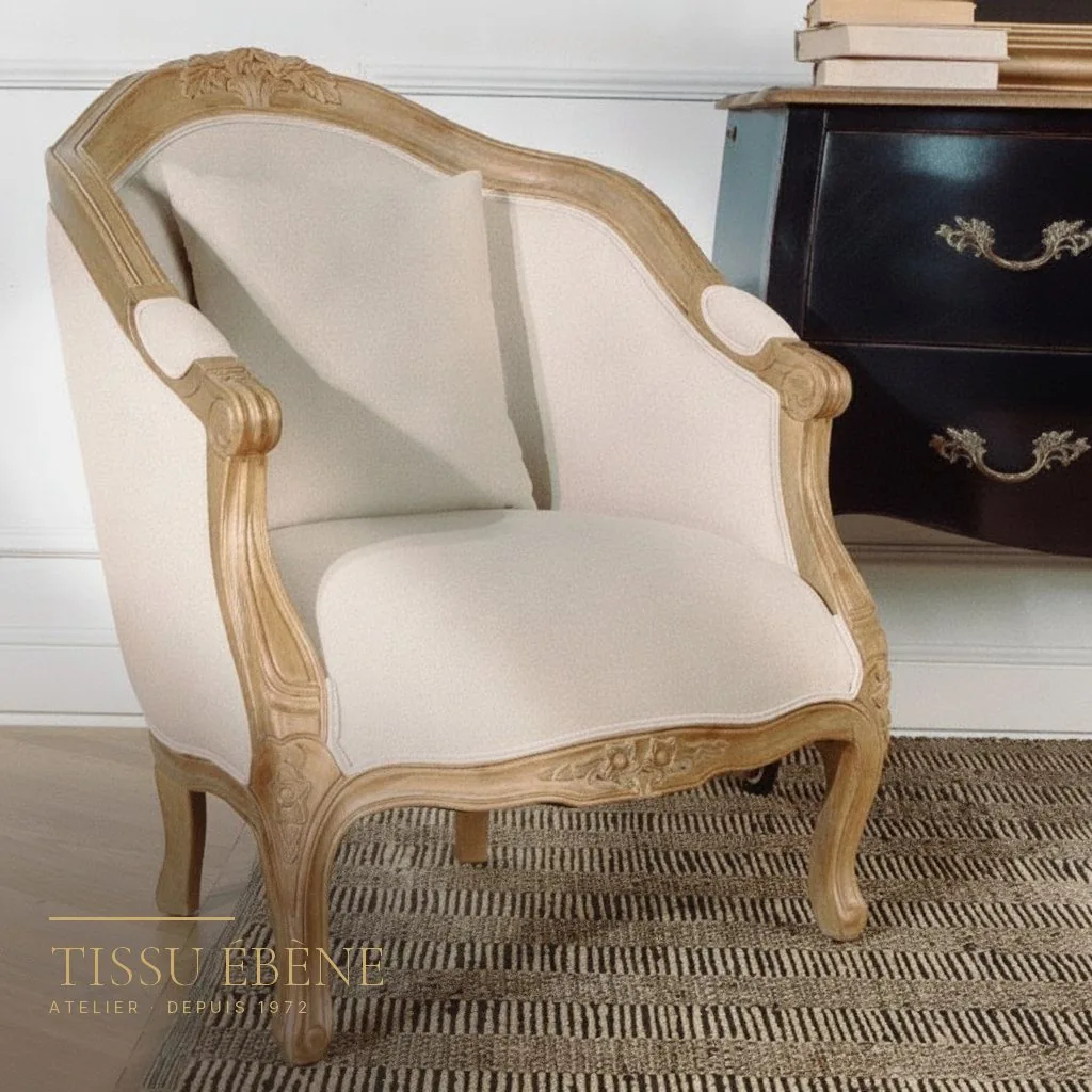 Bergère de style Louis XV en bois naturel sculpté, garnie d&rsquo;un tissu ivoire uni