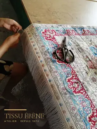 Reprise à la main de la frange d’un tapis fait main, à l’atelier